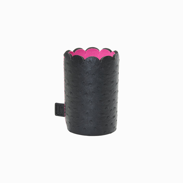 Can Couture vegan leather can sleeve in Edie black ostrich, empty, showing the scalloped edge, pink lining and brand tab