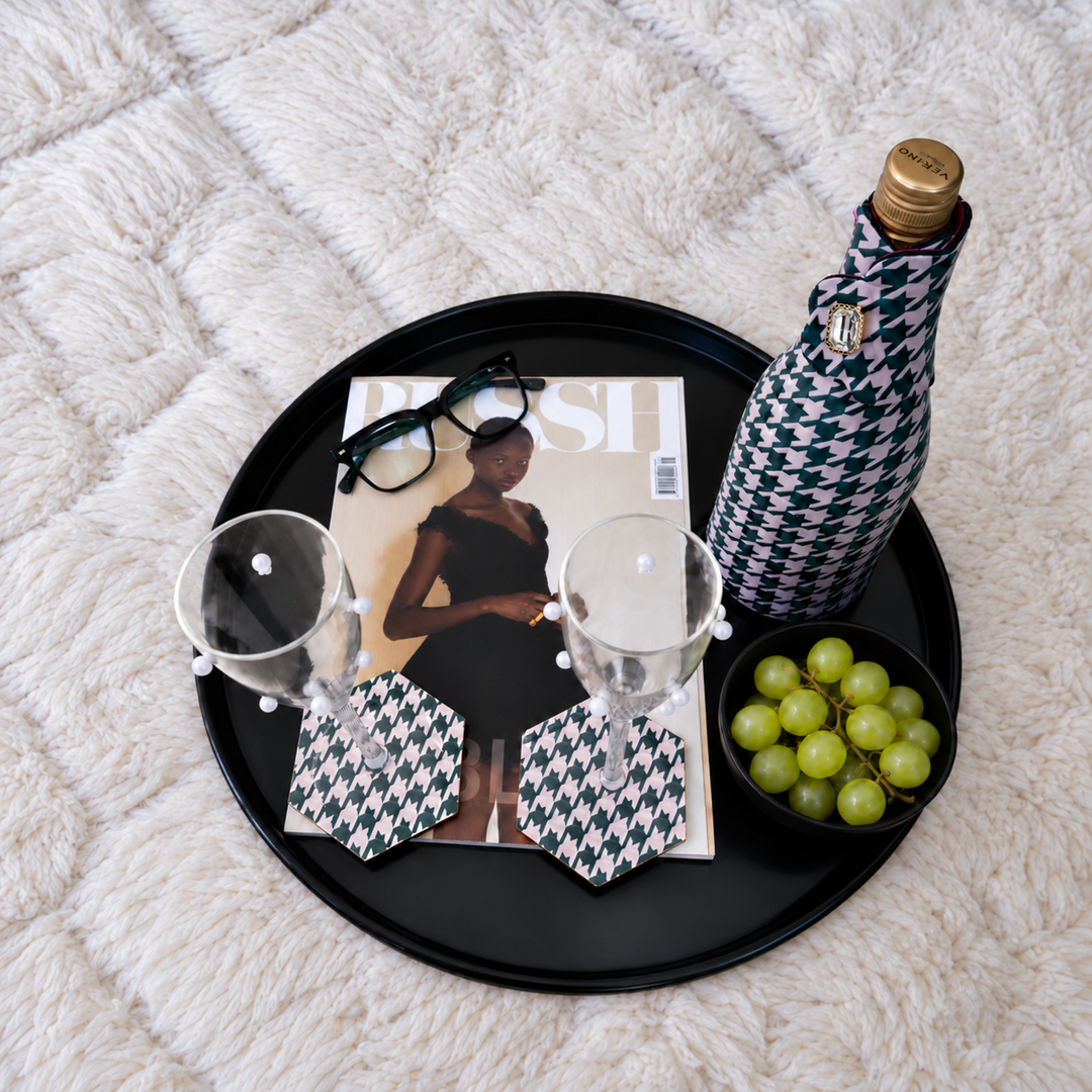 The Nightcap set: Bottle Couture wine bottle cooler and Style Tiles coasters in houndstooth print on a black tray with a magazine