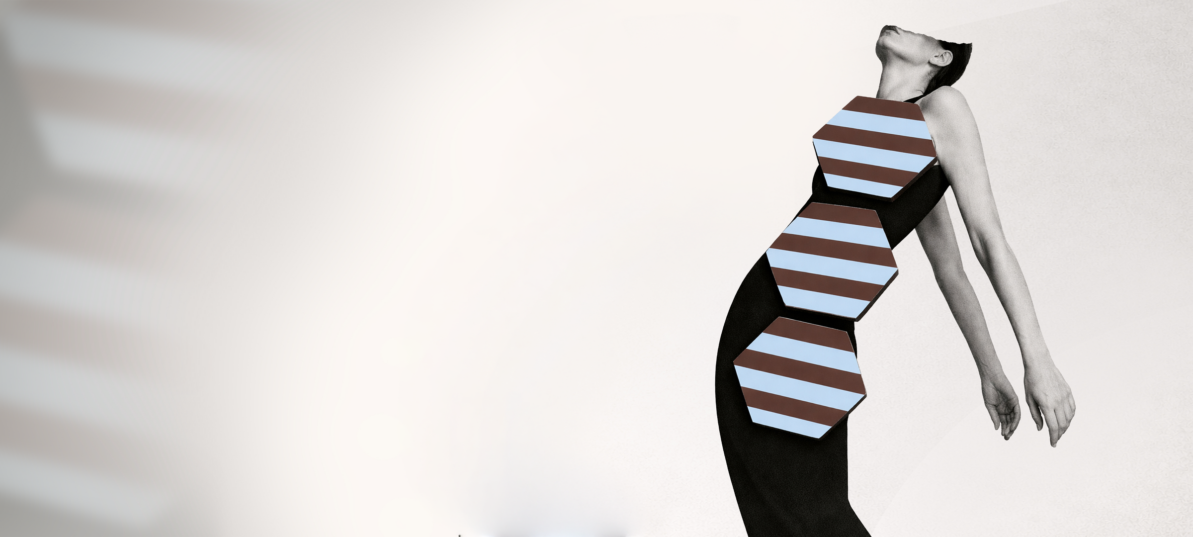 Black and white image of model styled with blue and chocolate striped hexagonal coasters