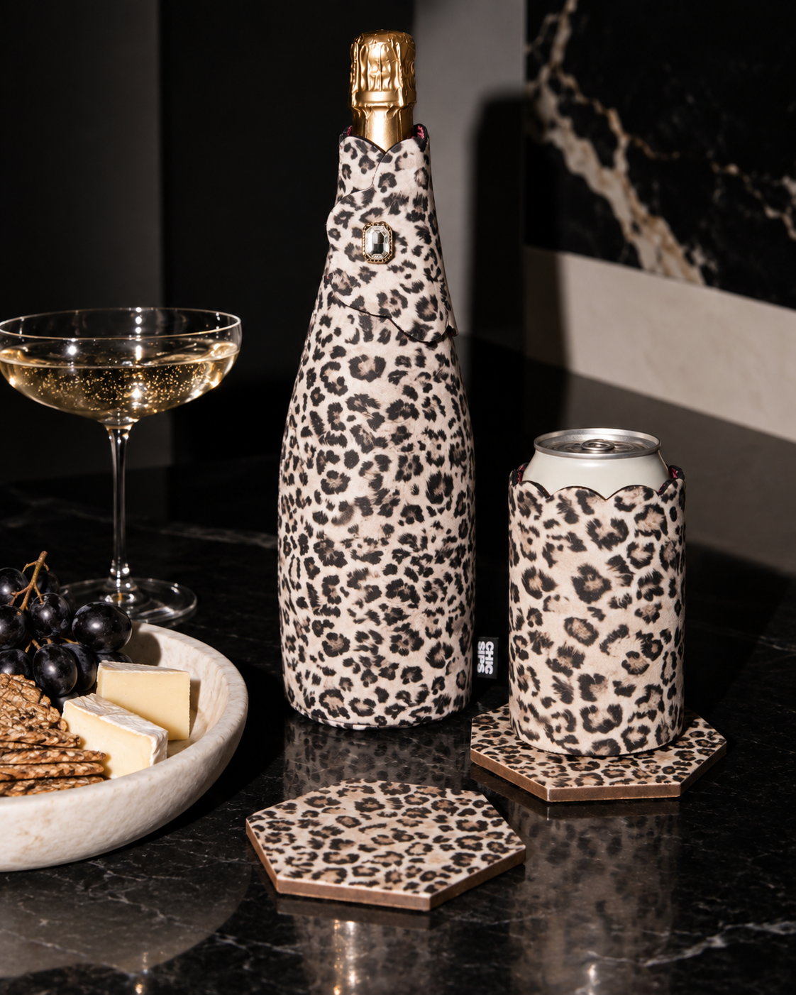 The Full Look in Catwalk leopard print: wine bottle cooler, can sleeve and coasters with champagne, cheese and grapes