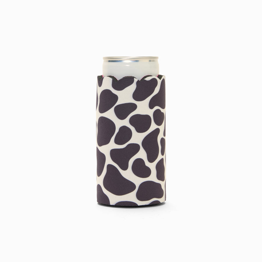 Cow print can sleeve with scalloped edge, holding a can