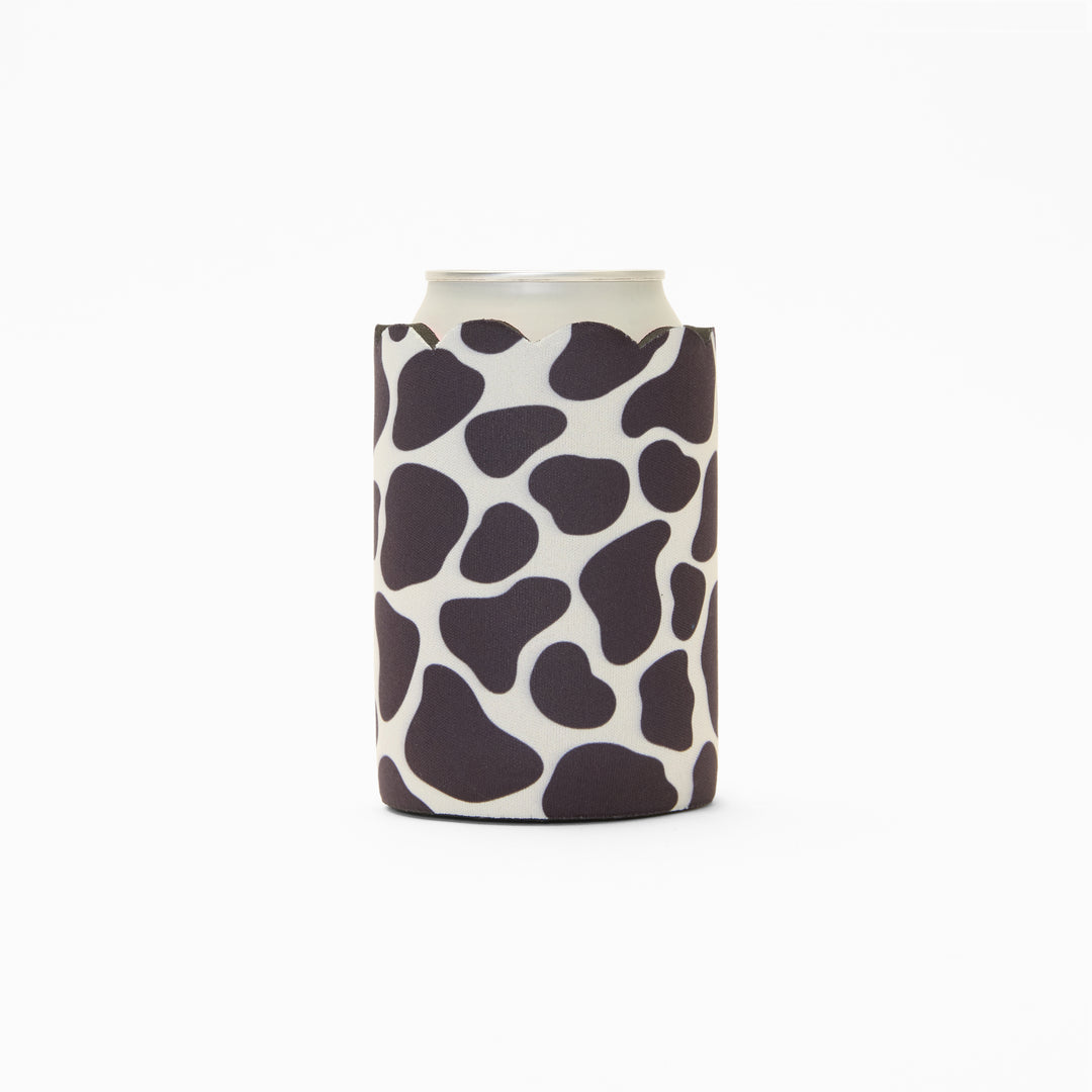 Cow print can sleeve with scalloped edge, holding a can