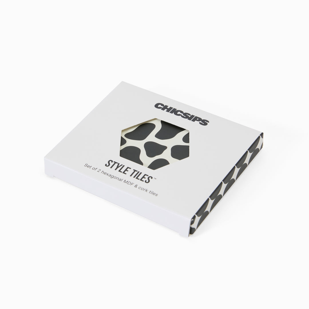 Style Tiles packaging box with hexagon window showing cow print coaster