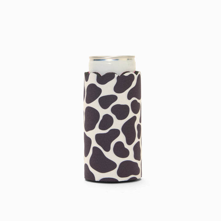Cow print can sleeve with scalloped edge, holding a can