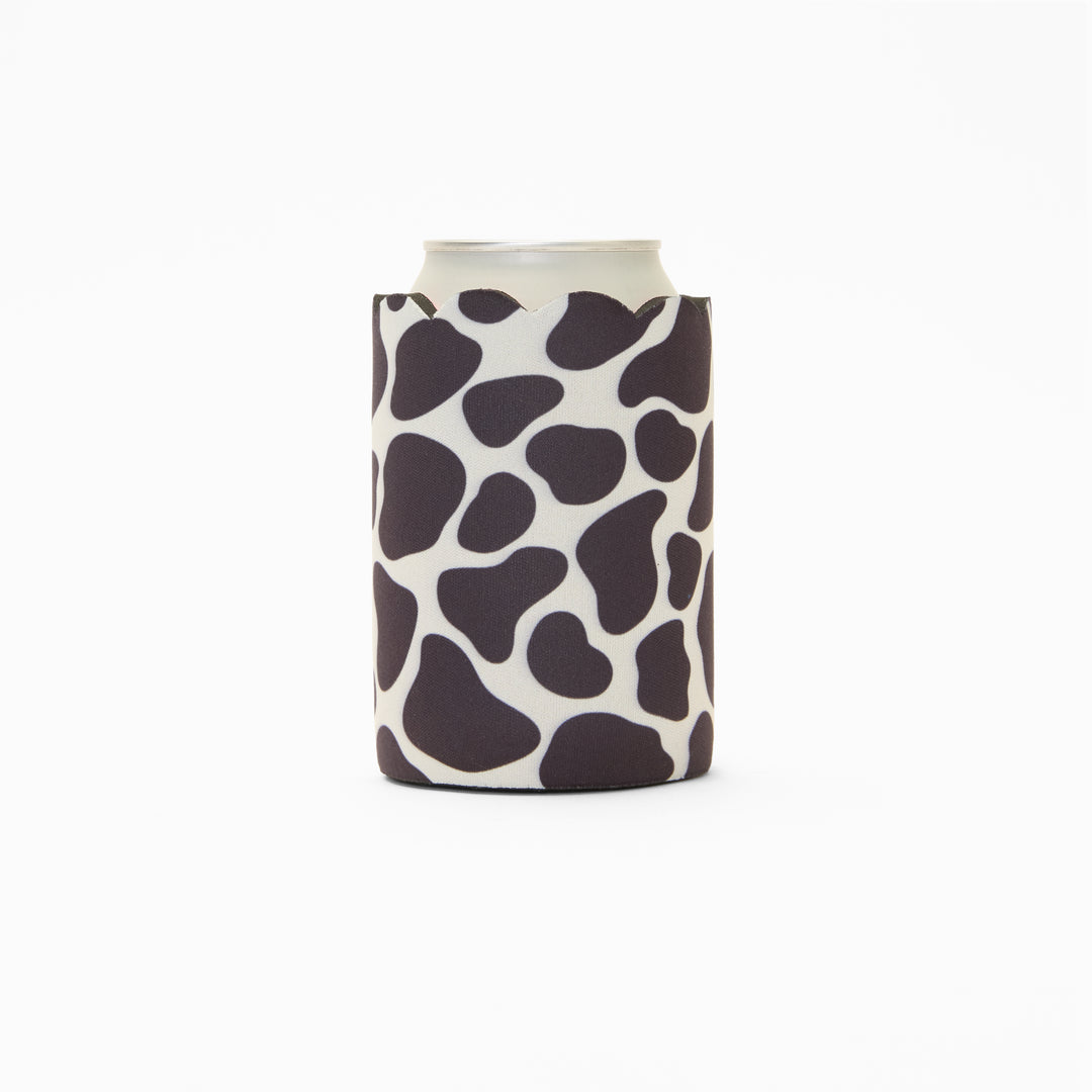 Cow print can sleeve with scalloped edge, holding a can