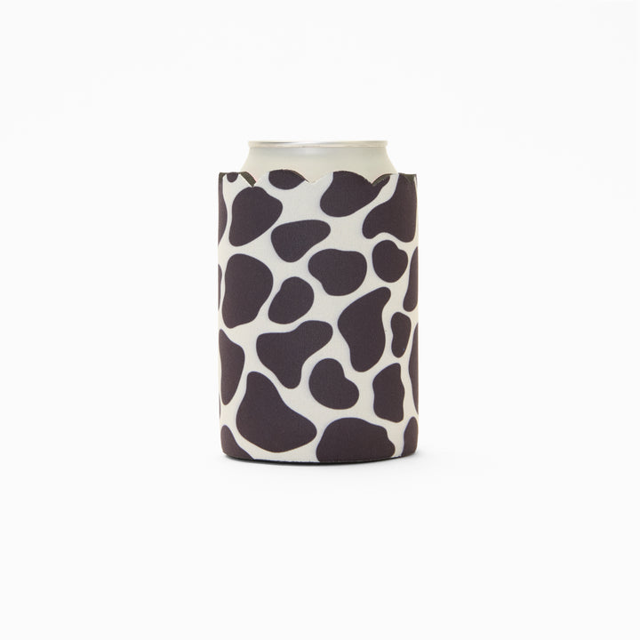 Cow print can sleeve with scalloped edge, holding a can