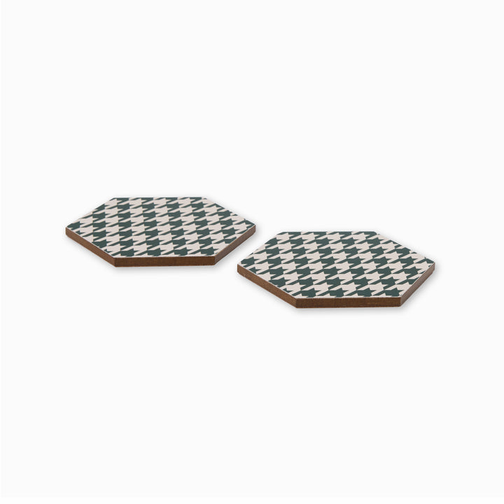Two green and cream houndstooth print hexagonal coasters shown from side angle
