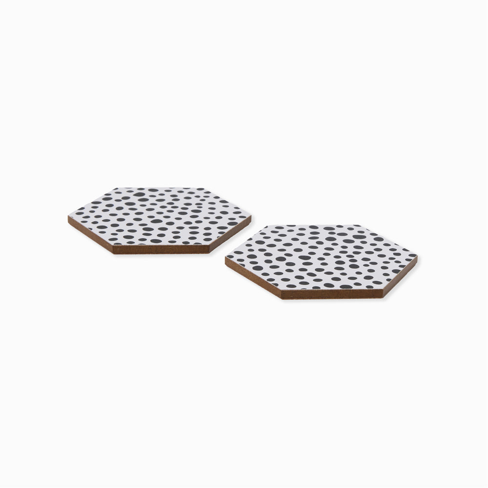 Two two black and white polka dot hexagonal coasters shown from side angle