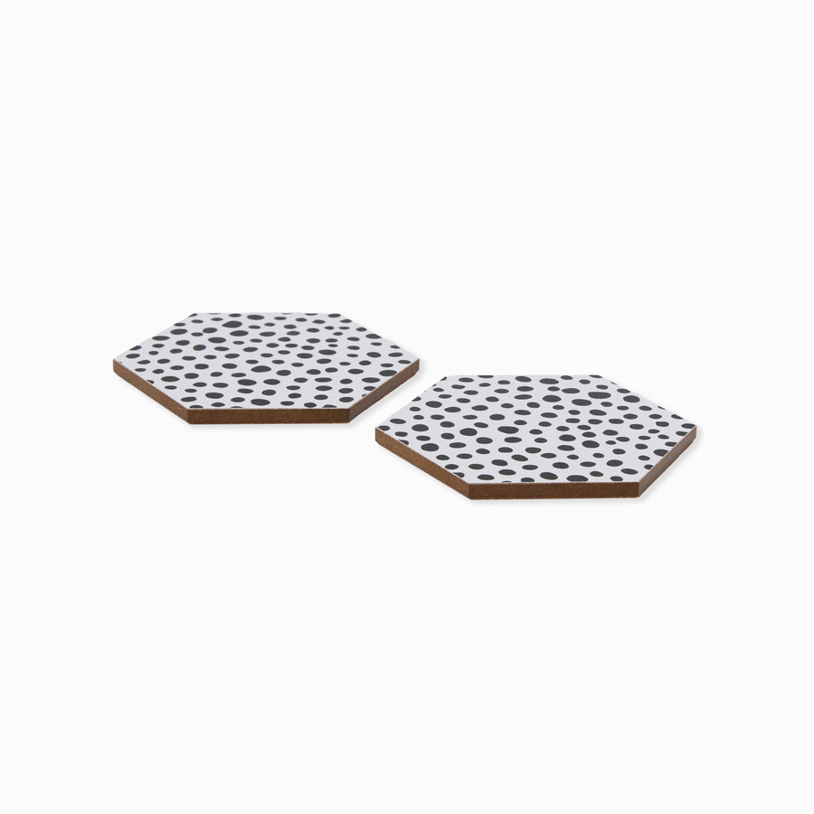 Two two black and white polka dot hexagonal coasters shown from side angle