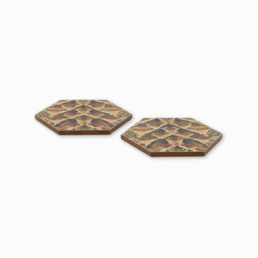 Two snake print hexagonal coasters shown from side angle